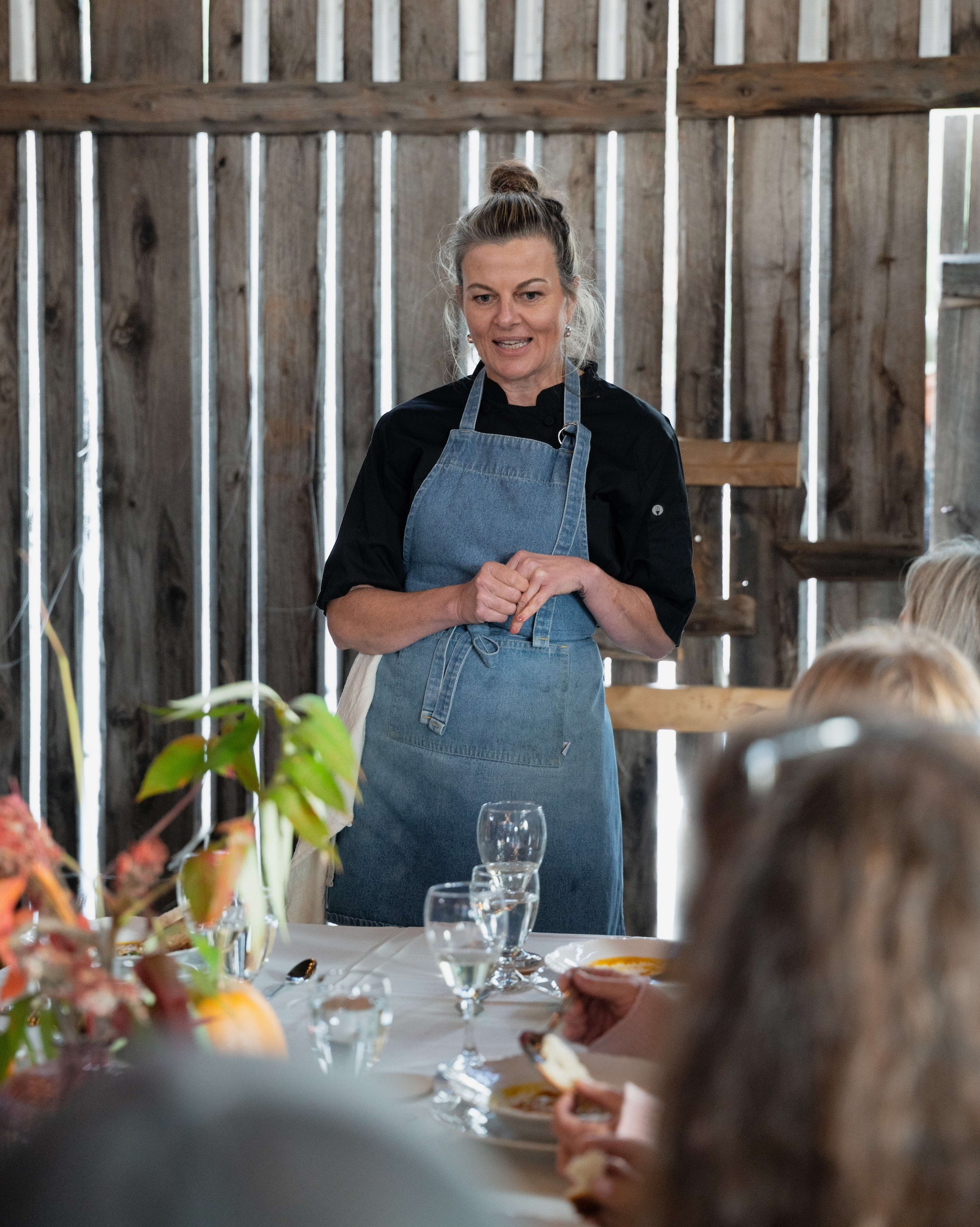 Chef presenting at an In Autumn cooking demonstration in a rustic barn