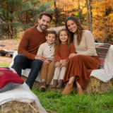 Family posing on hay bales against fall colours at the In Autumn mini photo sessions
